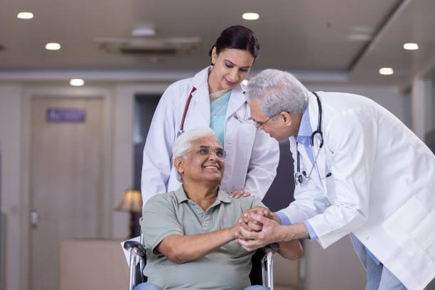 Doctors comforting disabled elderly patient at hospital